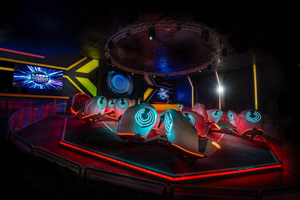 Firmenevents Wien - Futuristischer Innenraum der Breakdance 5 Attraktion im Laserdance Prater, mit Neonlichtern beleuchteten Sitzen.
