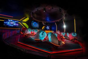 Futuristischer Innenraum der Breakdance 5 Attraktion im Laserdance Prater, mit Neonlichtern beleuchteten Sitzen.