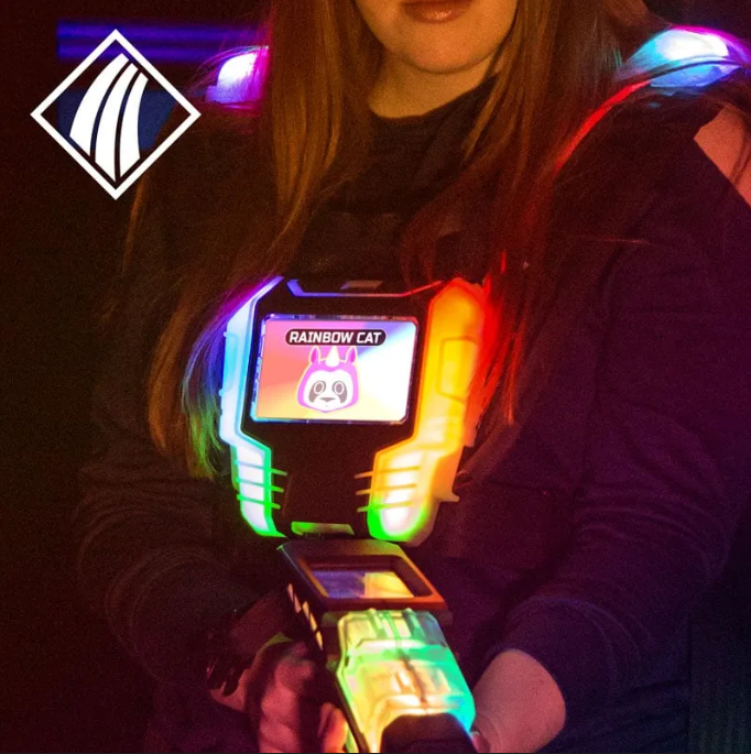 Person mit leuchtender Lasertag-Weste und Markierer; auf dem Brustdisplay steht „Rainbow Cat“ mit Katzenmotiv.