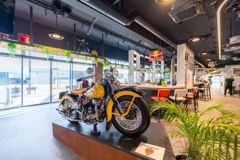 Stylischer Innenbereich von laserdance.at im Prater Wien mit klassischem gelben Motorrad und moderner Einrichtung.