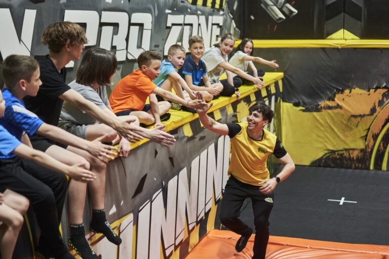 Kindergruppe in der Indoor-Arena von laserdance.at im Wiener Prater beim interaktiven Spiel mit einem Trainer